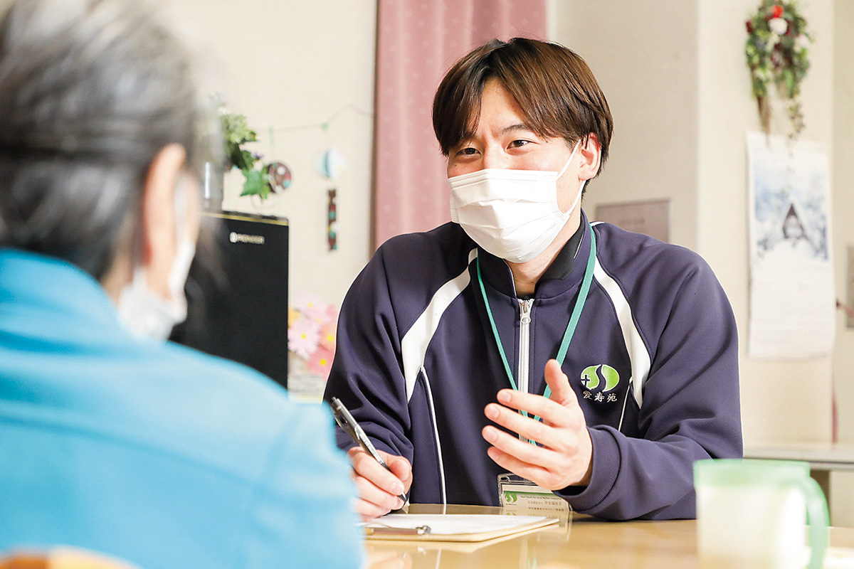 施設利用者に説明をする男性の写真