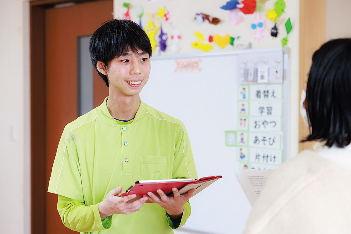 施設利用者に説明をする男性の写真